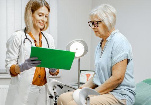 Doctor reviewing notes with an older woman during a 75 years and over health assessment