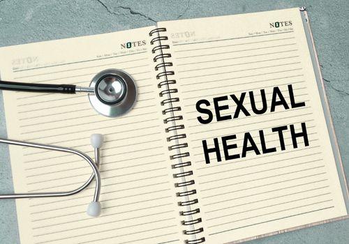 Notebook with the words sexual health written on it beside a stethoscope