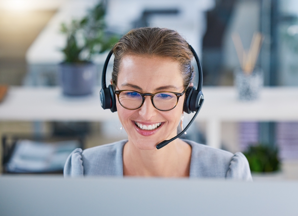 Reception team member wearing a headset answering calls at Harbour Town Doctors in Biggera Waters