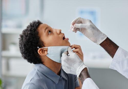 Nurse giving a child an oral vaccine during a childhood immunisation appointment