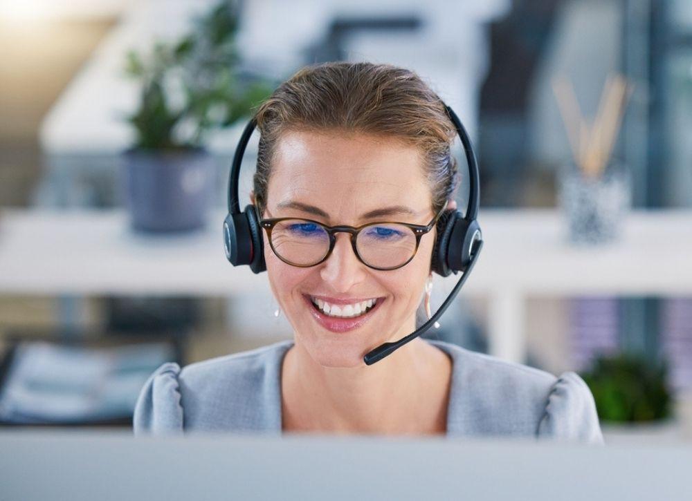 Reception team member wearing a headset answering calls at Harbour Town Doctors in Biggera Waters